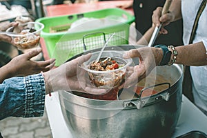 Volunteers are helping to give free food to the hungry homeless : food service and food donation concept