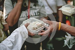 Volunteers are helping to give free food to the hungry homeless : food service and food donation concept