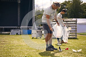 Volunteers Picking Up Litter After Outdoor Event Like Concert Or Music Festival