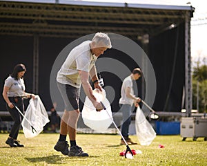 Volunteers Picking Up Litter After Outdoor Event Like Concert Or Music Festival