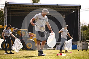 Volunteers Picking Up Litter After Outdoor Event Like Concert Or Music Festival