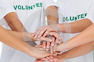 Volunteers piling up their hands together photo