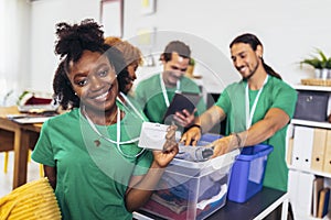 Volunteers putting clothes in donation boxes, social worker making notes charity