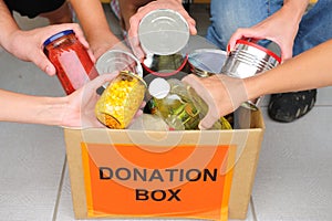 Volunteers putting food in donation box photo