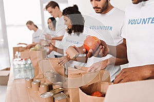 Volunteers putting food and drinks into bags photo