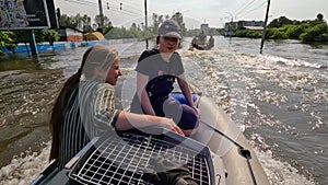 Volunteers sail on boat to evacuate animals and people after detonation of Hydroelectric Power Station. Flooding in