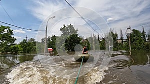 Volunteers sail on boat to evacuate animals and people after detonation of Hydroelectric Power Station. Flooding in