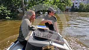 Volunteers sail on boat to evacuate animals and people after detonation of Hydroelectric Power Station. Flooding in