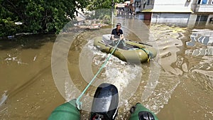 Volunteers sail on boat to evacuate animals and people after detonation of Hydroelectric Power Station. Flooding in