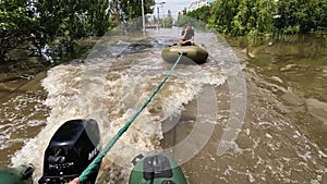 Volunteers sail on boat to evacuate animals and people after detonation of Hydroelectric Power Station. Flooding in