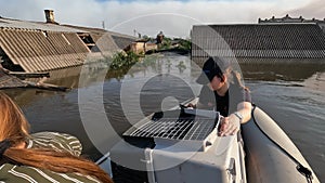 Volunteers sail on boat to evacuate chicken after detonation of Hydroelectric Power Station. Flooded houses in Kherson