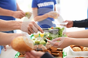 Volunteers serving food to poor people,