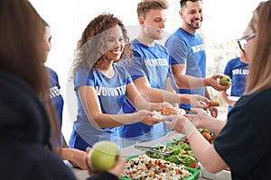 Volunteers serving food to poor people