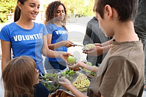 Volunteers serving food to poor people