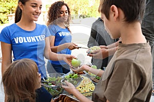 Volunteers serving food to poor people photo