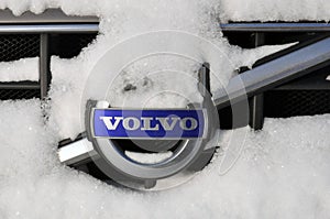 Volvo car logo on the car grill under a layer of snow