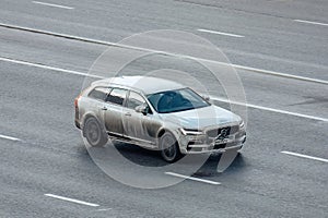 Volvo V90 car moving on the street. Estate vehicle driving along highway in city