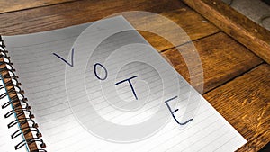 Vote, handwriting  text on paper, political message. Political text on office agenda. Concept of democracy, voting, politics. Copy