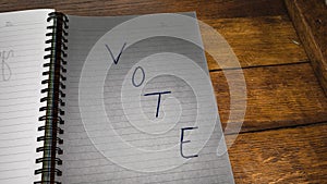 Vote, handwriting  text on paper, political message. Political text on office agenda. Concept of democracy, voting, politics. Copy