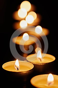 Votive candles burning in the darkness photo