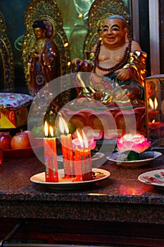 Votive candles and incense, with Buddha