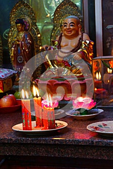 Votive candles and incense, with Buddha