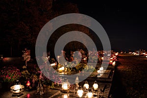 Votive candles lantern burning on the graves in Slovak cemetery at night time. All Saints' Day. Solemnity of All Saints