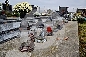 Votive candles lantern on the grave in Slovak cemetery. All Saints' Day. Solemnity of All Saints. All Hallows eve