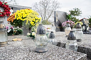 Votive candles lantern on the grave in Slovak cemetery. All Saints' Day. Solemnity of All Saints. All Hallows eve