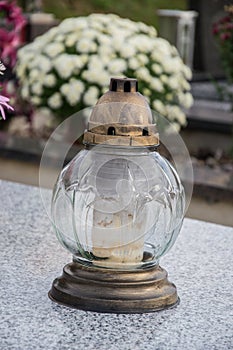 Votive candles lantern on the grave in Slovak cemetery. All Saints' Day. Solemnity of All Saints. All Hallows eve