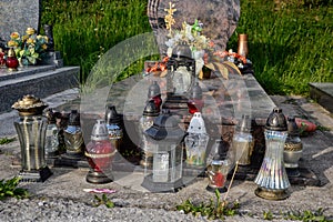 Votive candles lantern on the grave in Slovak cemetery. All Saints' Day. Solemnity of All Saints. All Hallows eve