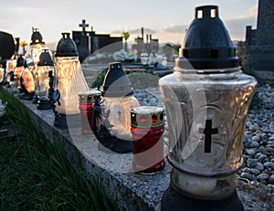 Votive candles lantern on the grave in Slovak cemetery. All Saints' Day. Solemnity of All Saints. All Hallows eve
