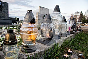 Votive candles lantern on the grave in Slovak cemetery. All Saints' Day. Solemnity of All Saints. All Hallows eve