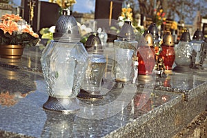 Votive candles lantern on the grave in Slovak cemetery. All Saints' Day. Solemnity of All Saints. All Hallows eve