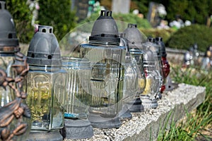 Votive candles lantern on the grave in Slovak cemetery. All Saints' Day. Solemnity of All Saints. All Hallows eve