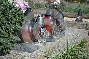 Votive candles lantern on the grave in Slovak cemetery. All Saints' Day. Solemnity of All Saints. All Hallows eve