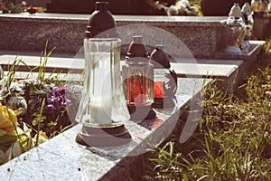 Votive candles lantern on the grave in Slovak cemetery. All Saints' Day. Solemnity of All Saints. All Hallows eve