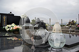 Votive candles lantern on the grave in Slovak cemetery. All Saints' Day. Solemnity of All Saints. All Hallows eve photo