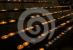 votive candles lit by the faithful after reciting a prayer inside the Church