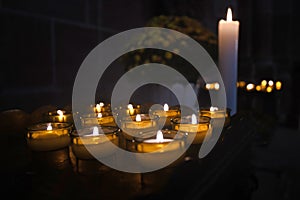 Votive or prayer candles burning as a votive offering in an act of Christian prayer inside of church