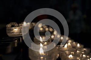 Votive prayer candles inside a catholic church on a candle rack