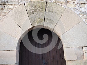 Voussoir arch in the middle of the side access door to the church of San Urbano de Montsonis, Lerida, Spain, Europe photo