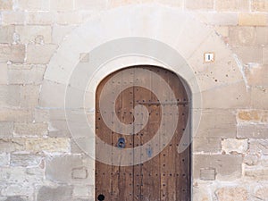Voussoir entrance and wooden door of the church of fondarella, lerida, spain