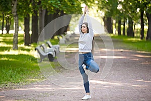 Vriksasana posture on park alley