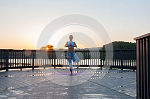 Vrikshasana pose. Young woman is doing yoga on the sunrise