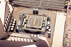 VRM zone, voltage regulator module, CPU socket with protector cap and memory sockets on modern motherboard