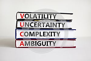 VUCA volatility, uncertainty, complexity, ambiguity symbol. Words `VUCA volatility, uncertainty, complexity, ambiguity` on books