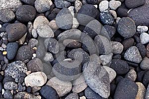 Vulcanic dark round stones at the shore of Ischia, Italy