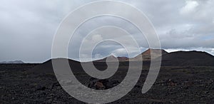 Vulcano e panorama con nuvole bianche e rocce vulcaniche