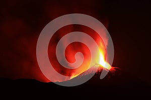 Panoramica del vulcano di Sicilia: Etna in eruzione durante la notte con sfondo scuro del cielo notturno photo